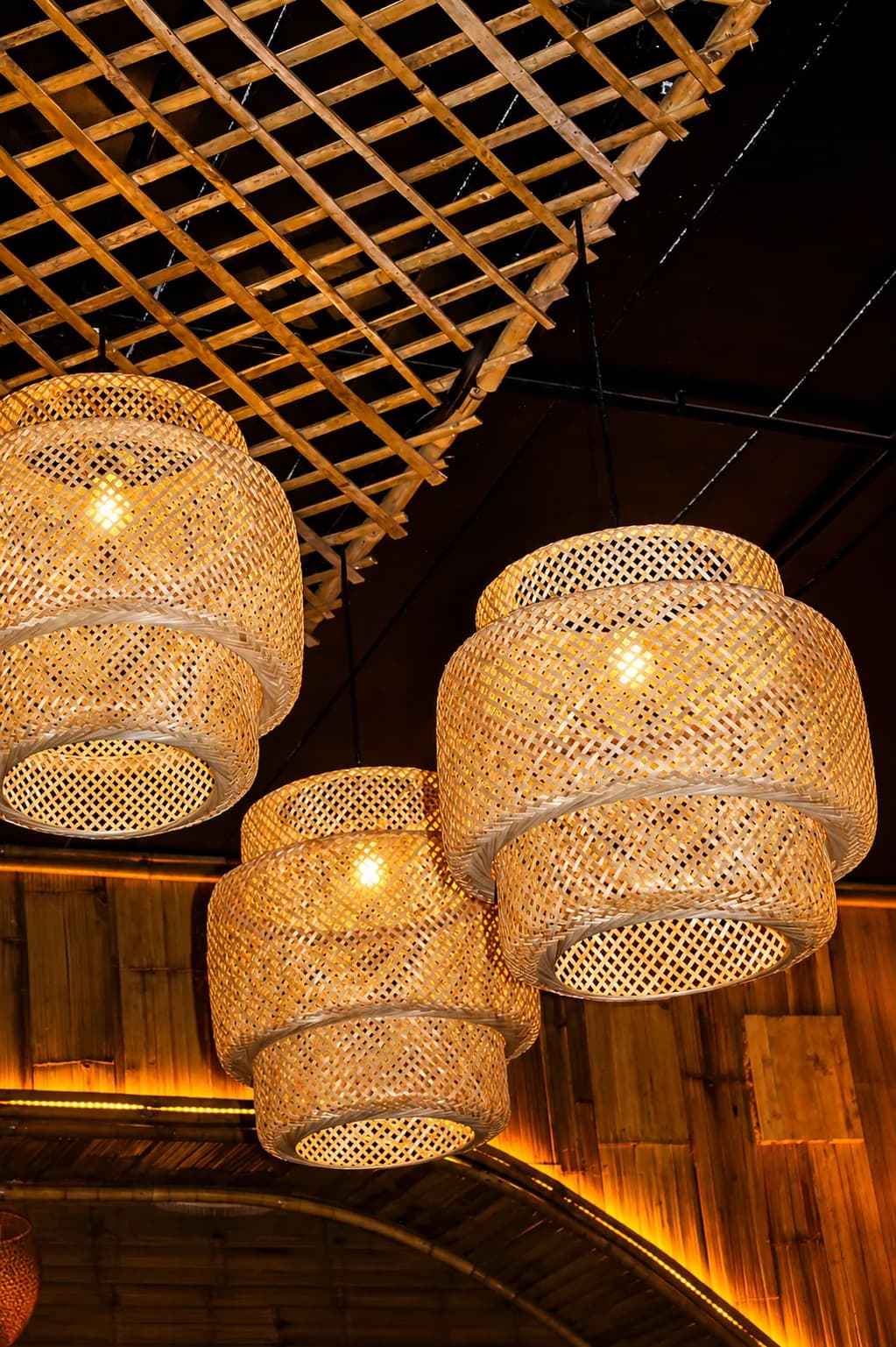 Woven bamboo pendant lights glowing inside MESA Restaurant & Bar